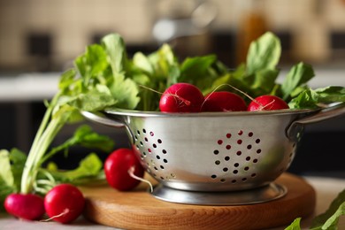 Photo of Metal colander with fresh radishes on table, closeup