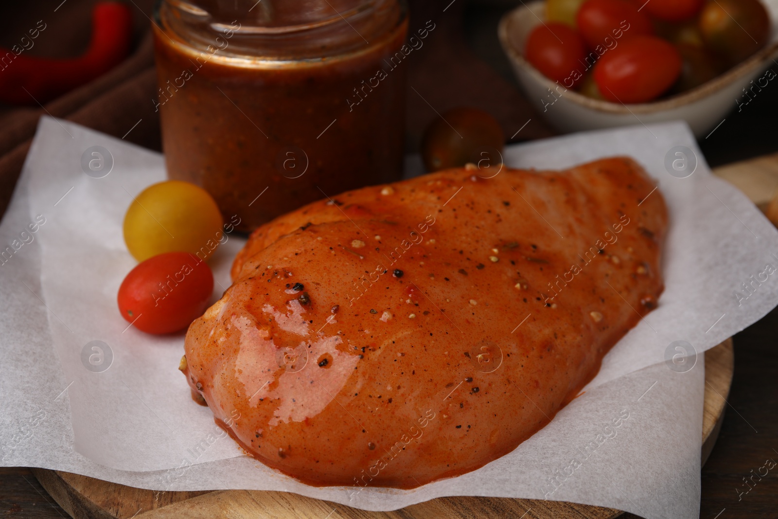 Photo of Fresh marinade and raw chicken fillets on wooden table, closeup