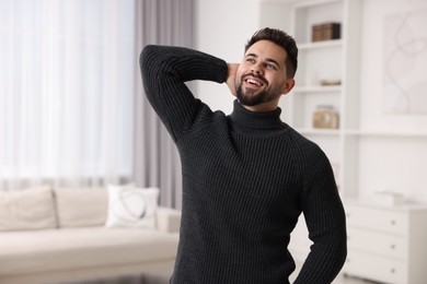 Photo of Happy man in stylish sweater at home