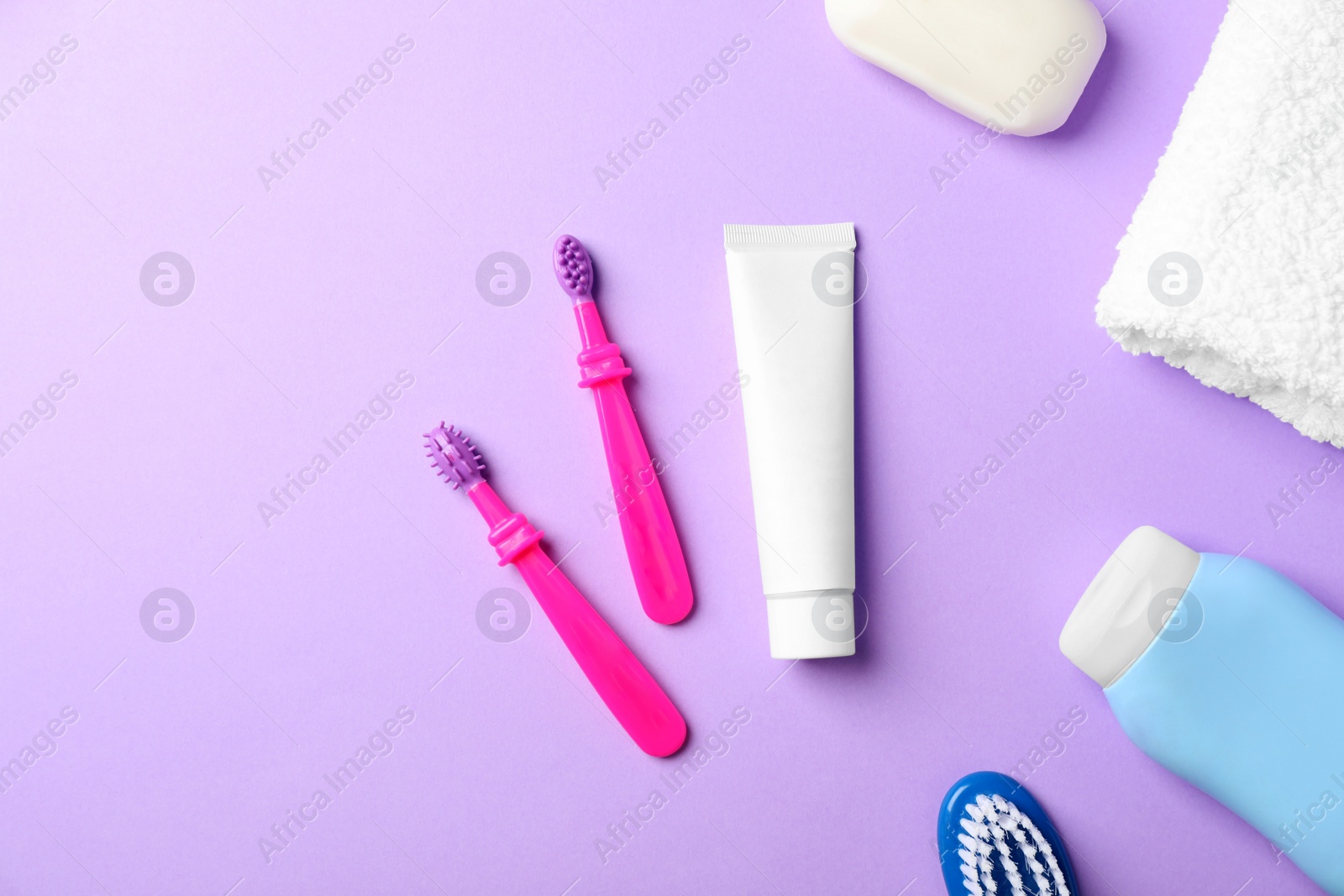 Photo of Flat lay composition with baby toothbrushes and toiletries on color background