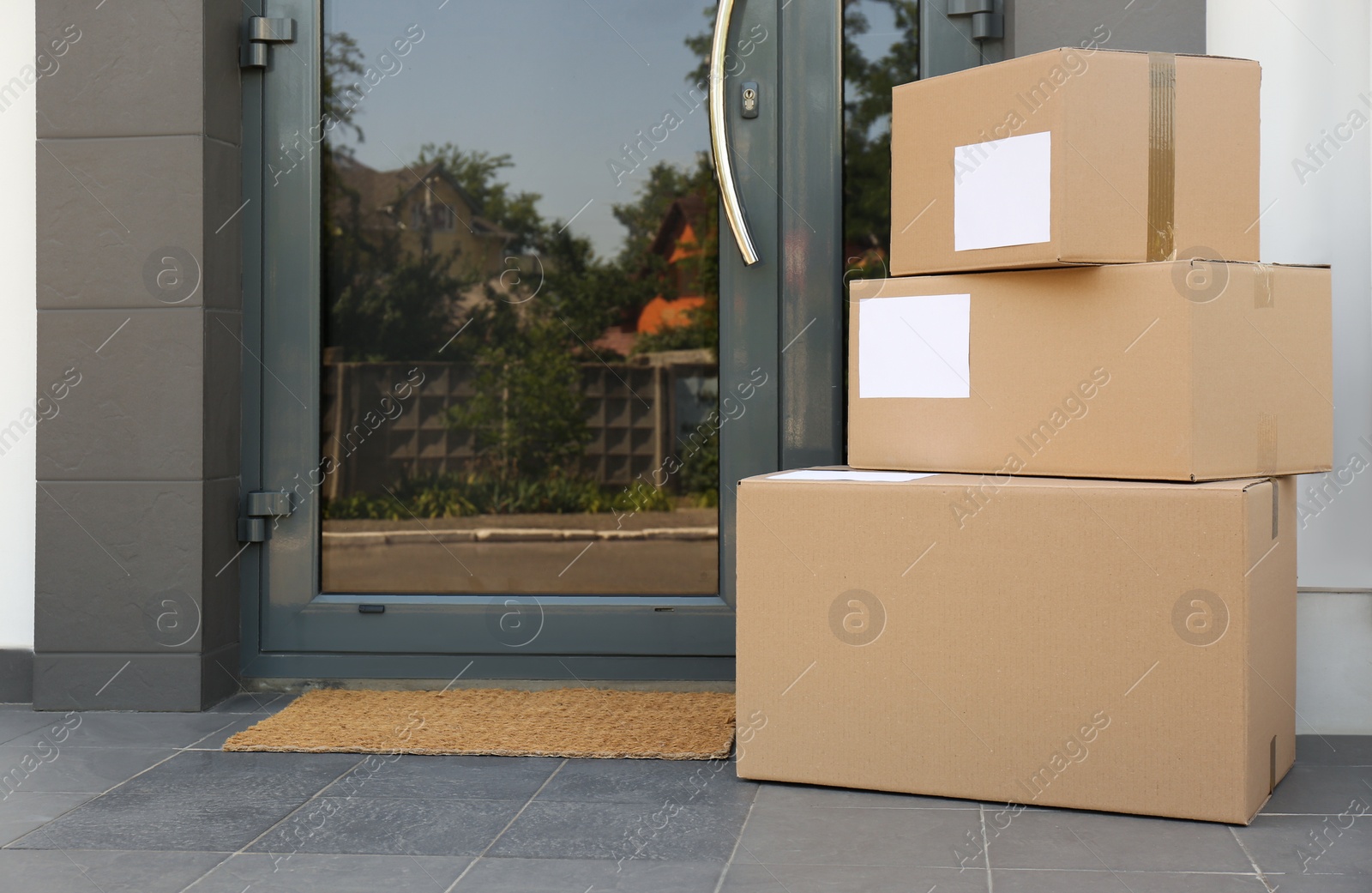 Photo of Cardboard boxes near door. Parcel delivery service