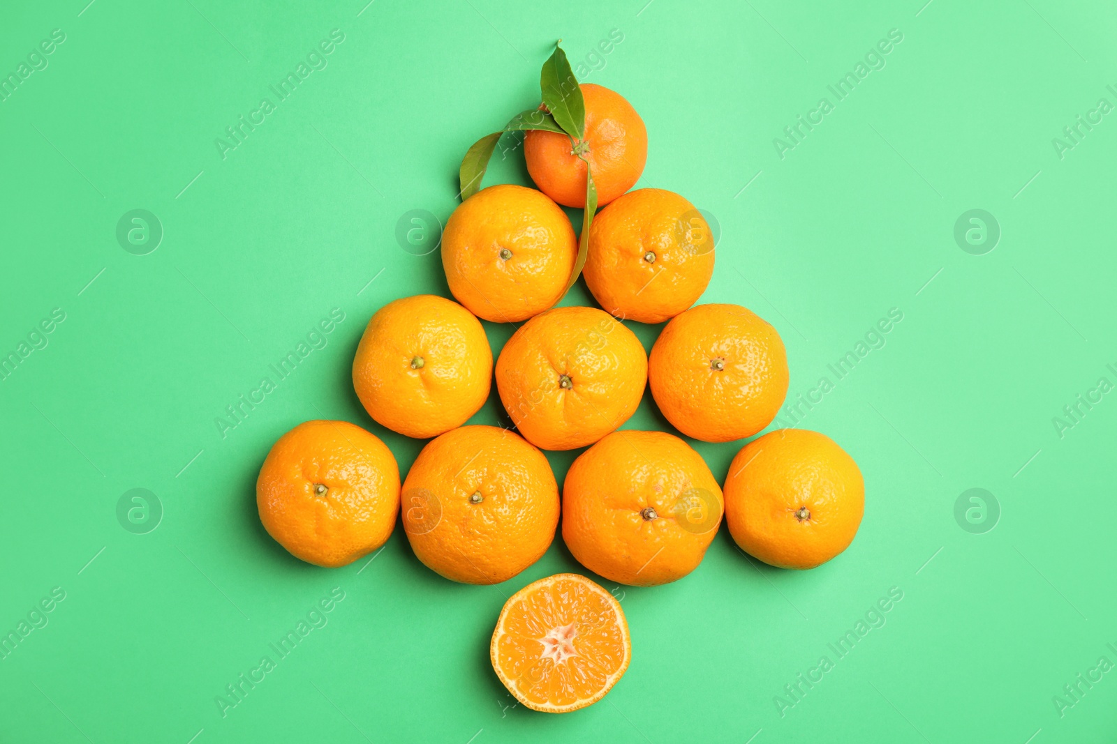 Photo of Christmas tree made of ripe tangerines on color background, top view