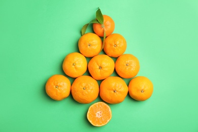 Photo of Christmas tree made of ripe tangerines on color background, top view