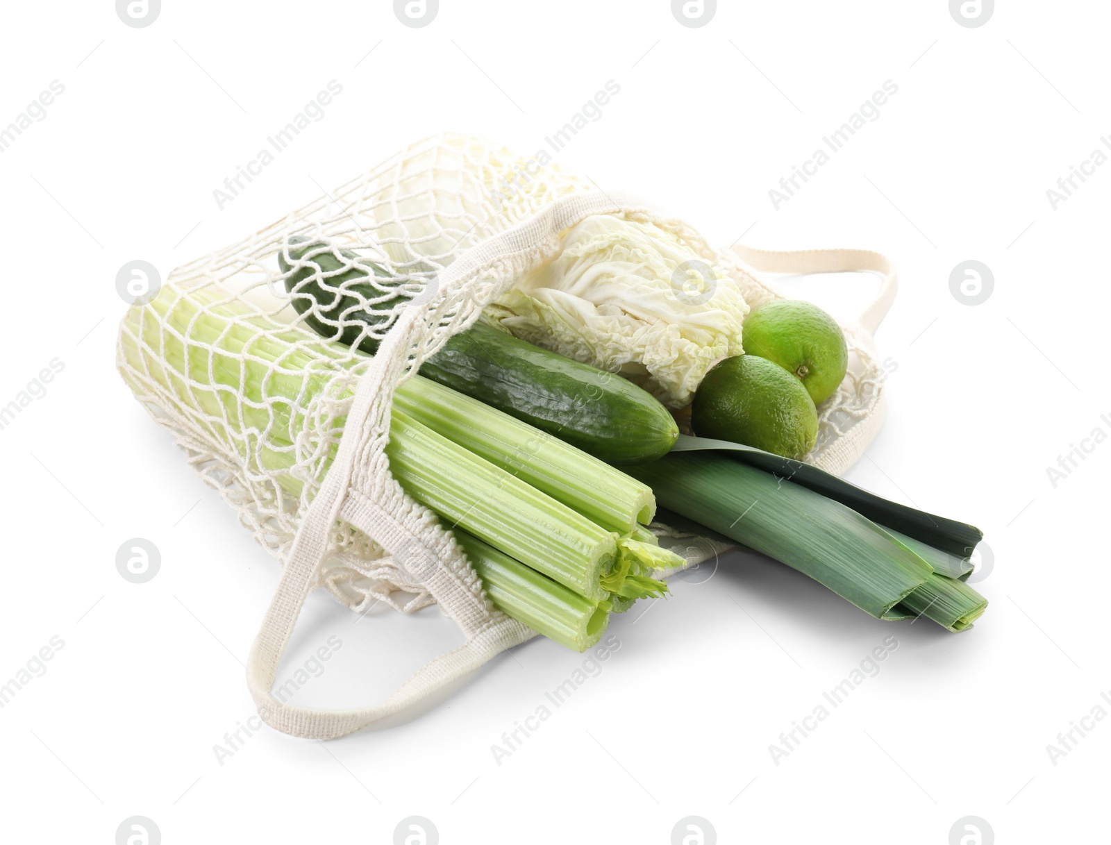 Photo of String bag with different vegetables isolated on white