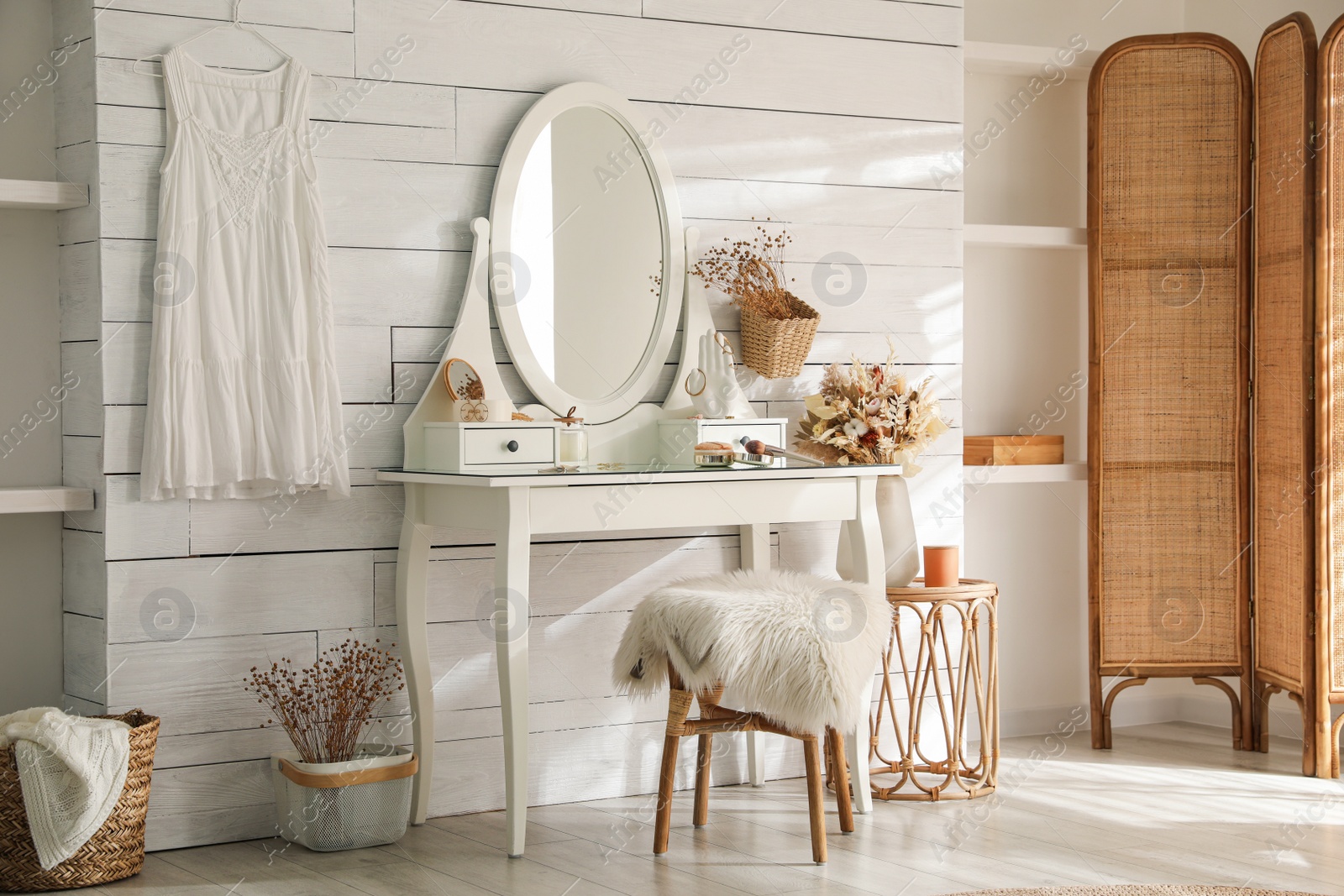 Photo of Wooden dressing table with decorative elements and makeup products in room. Interior design