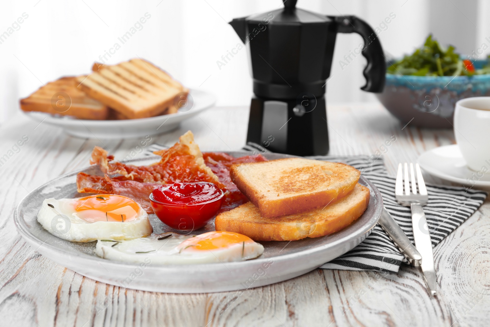 Photo of Plate with fried eggs, bacon, toasts and sauce on wooden background