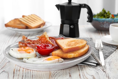 Photo of Plate with fried eggs, bacon, toasts and sauce on wooden background