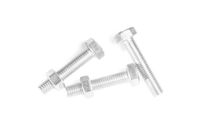 Metal bolts with hex nuts on white background, top view