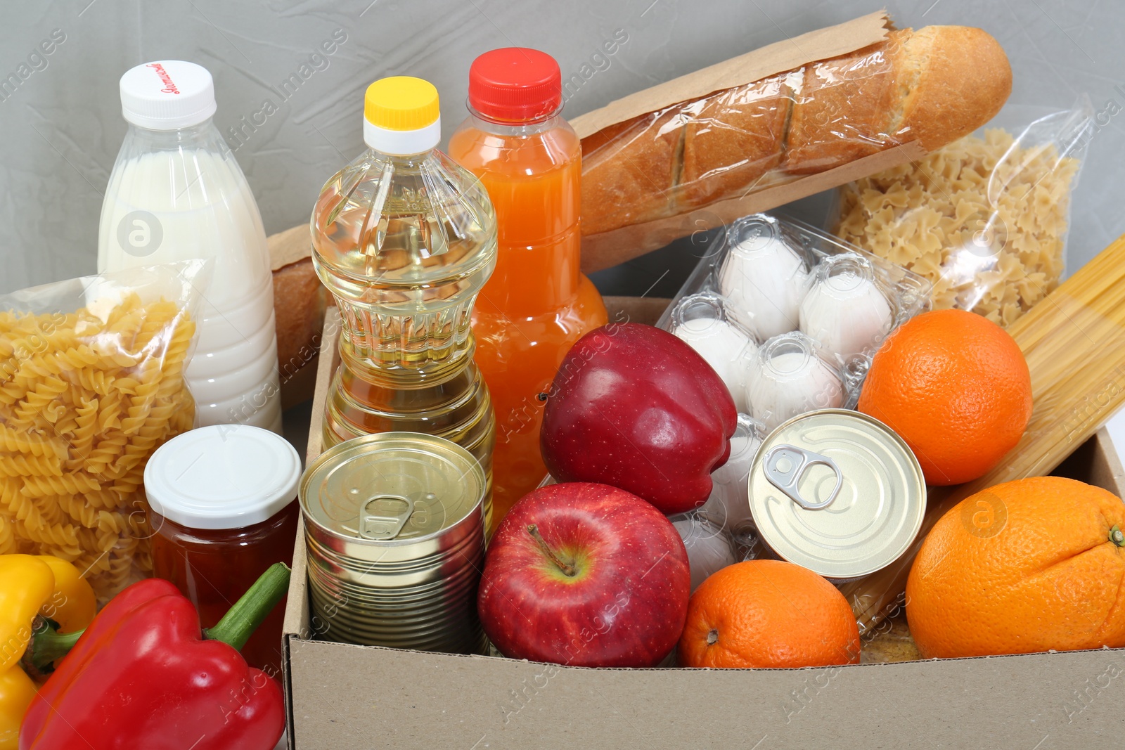 Photo of Humanitarian aid. Different food products for donation on grey background, closeup