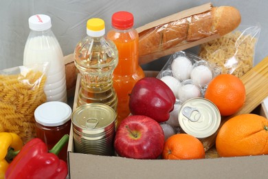 Humanitarian aid. Different food products for donation on grey background, closeup