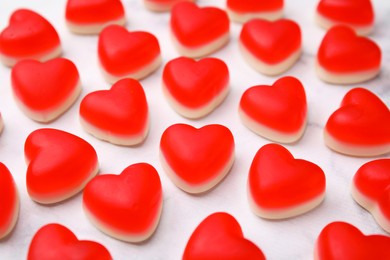 Delicious heart shaped jelly candies on white table, closeup