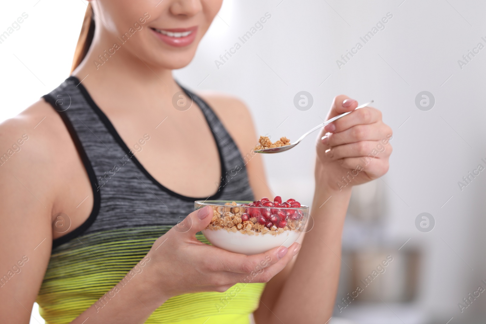 Photo of Young woman in fitness clothes having healthy breakfast at home, closeup