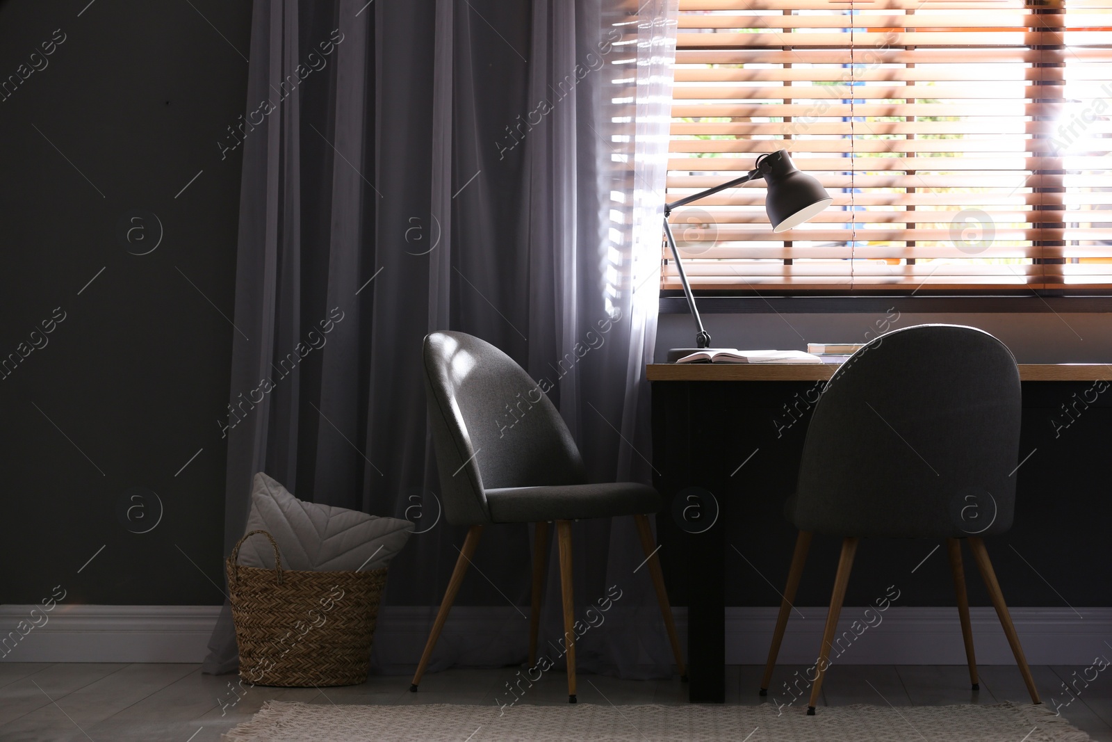 Photo of Comfortable chairs and desk near window with elegant curtains in room