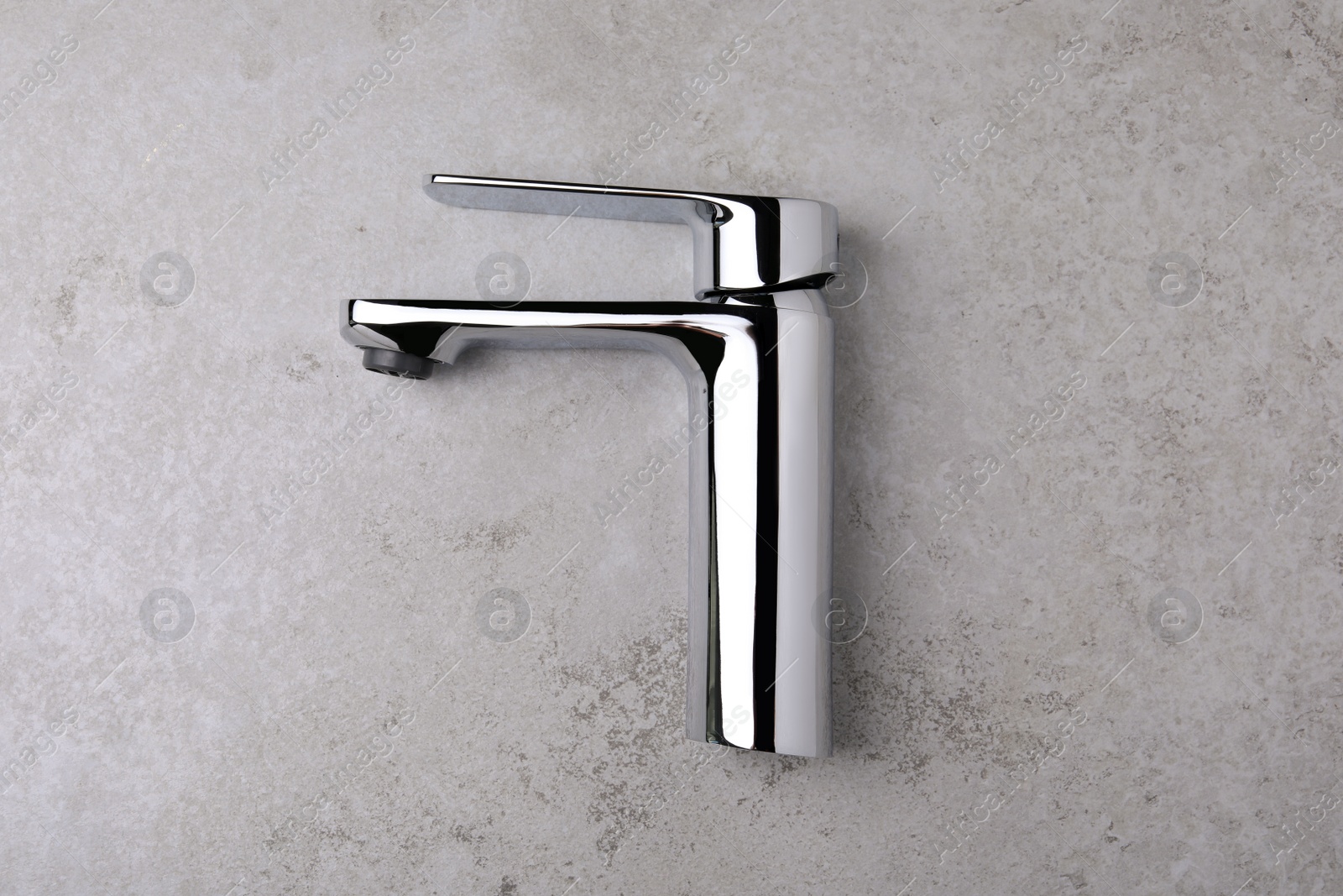 Photo of Single handle water tap on grey table, top view