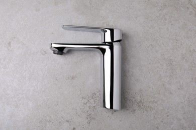 Photo of Single handle water tap on grey table, top view