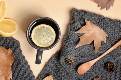 Flat lay composition with hot cozy drink and autumn leaves on color background