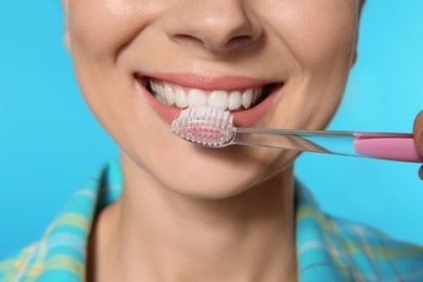 Woman with toothbrush on color background, closeup