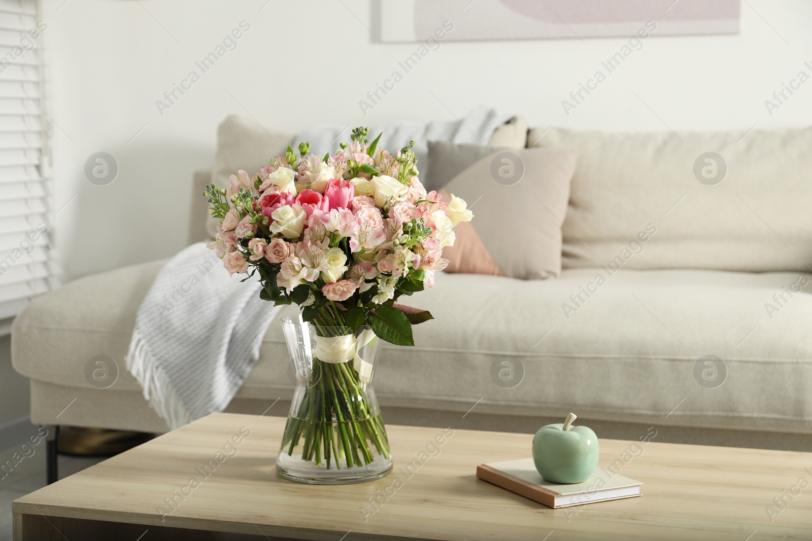 Photo of Beautiful bouquet of fresh flowers in vase on wooden table indoors