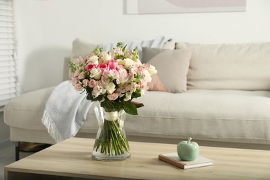 Beautiful bouquet of fresh flowers in vase on wooden table indoors