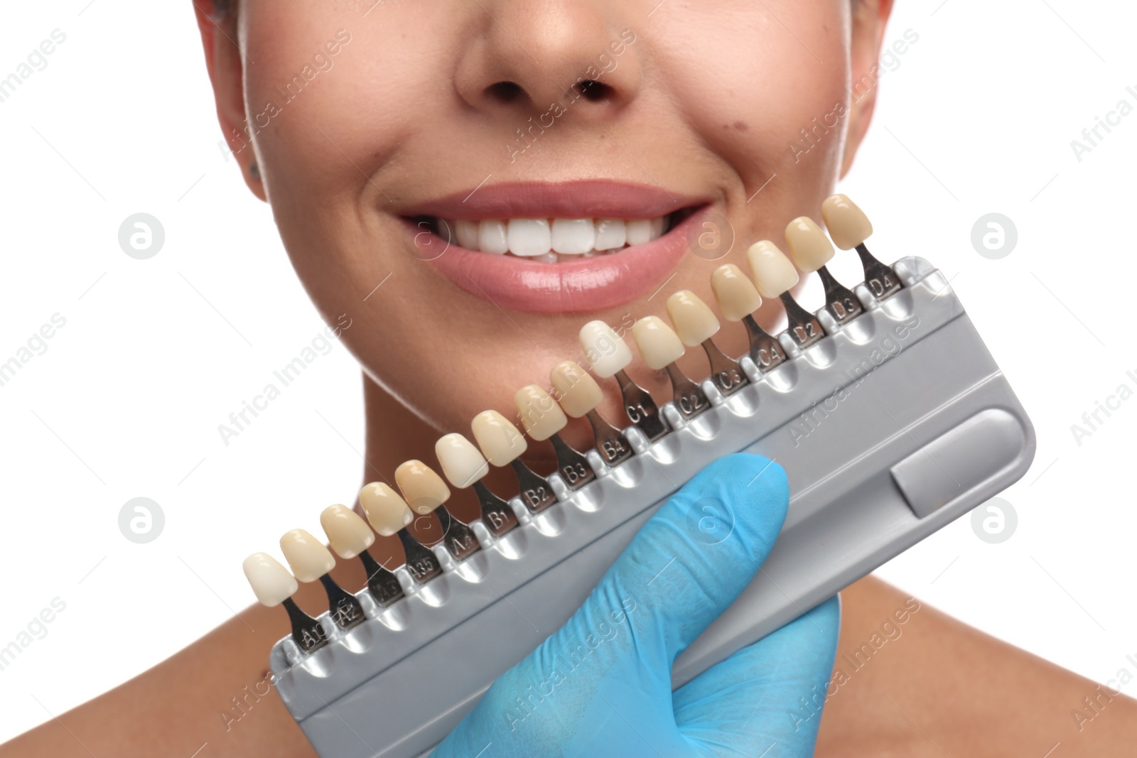 Photo of Doctor checking young woman's teeth color on white background, closeup. Cosmetic dentistry