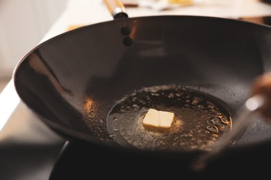 Frying pan with melted butter on stove, closeup