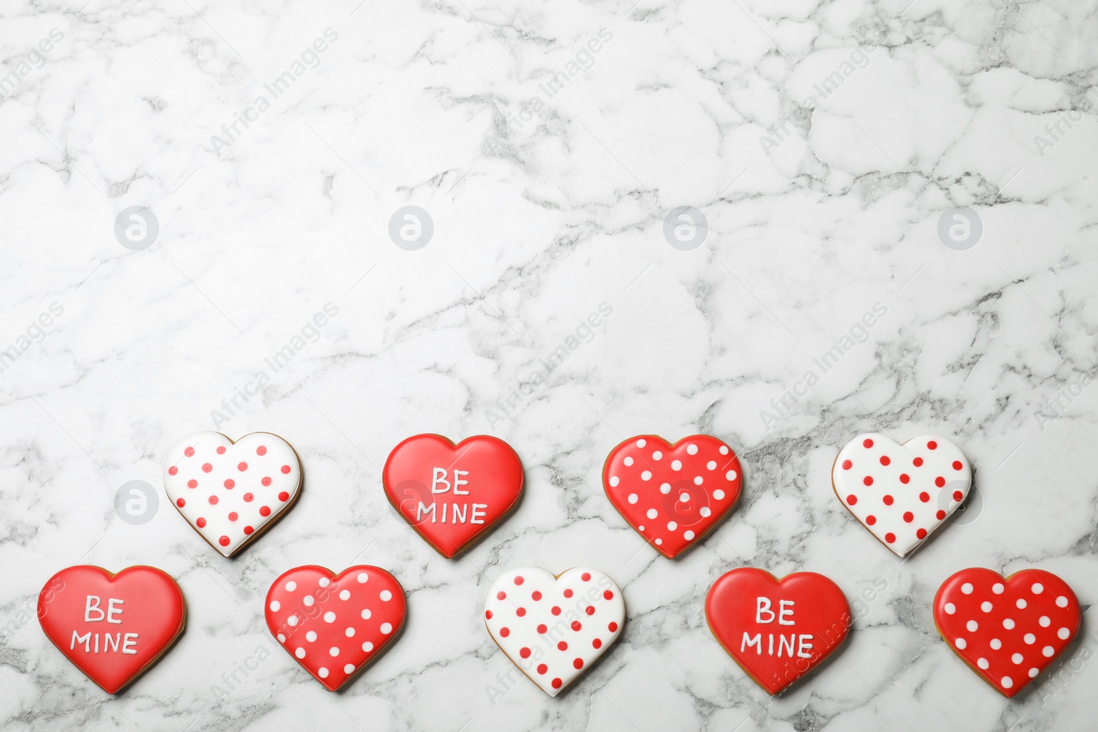 Photo of Valentine's day cookies on white marble table, flat lay. Space for text