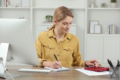 Professional accountant working at wooden desk in office