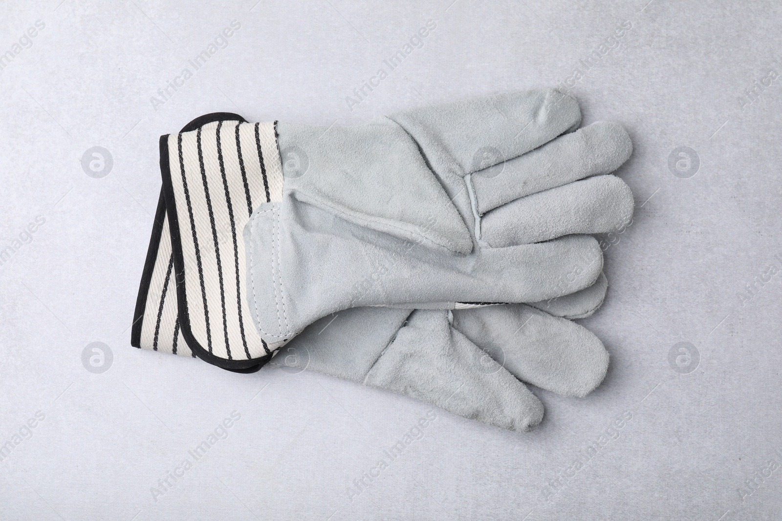Photo of Pair of color gardening gloves on light grey table, top view