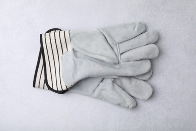 Pair of color gardening gloves on light grey table, top view