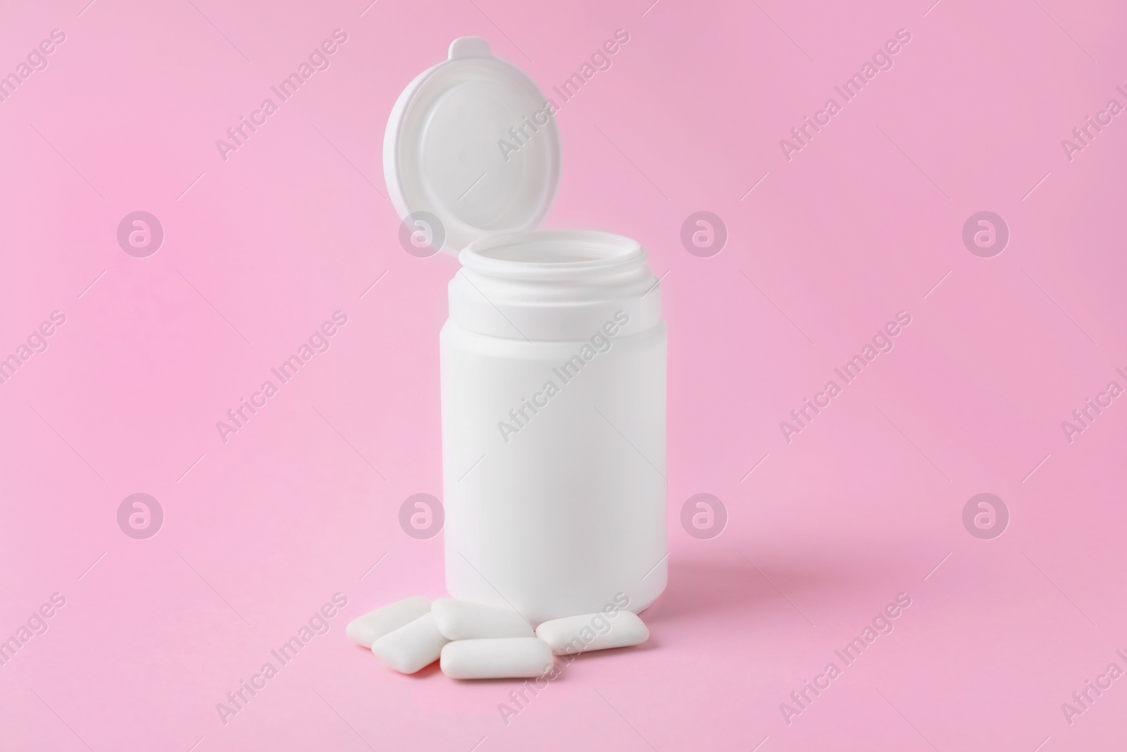 Photo of Jar with chewing gums on pink background