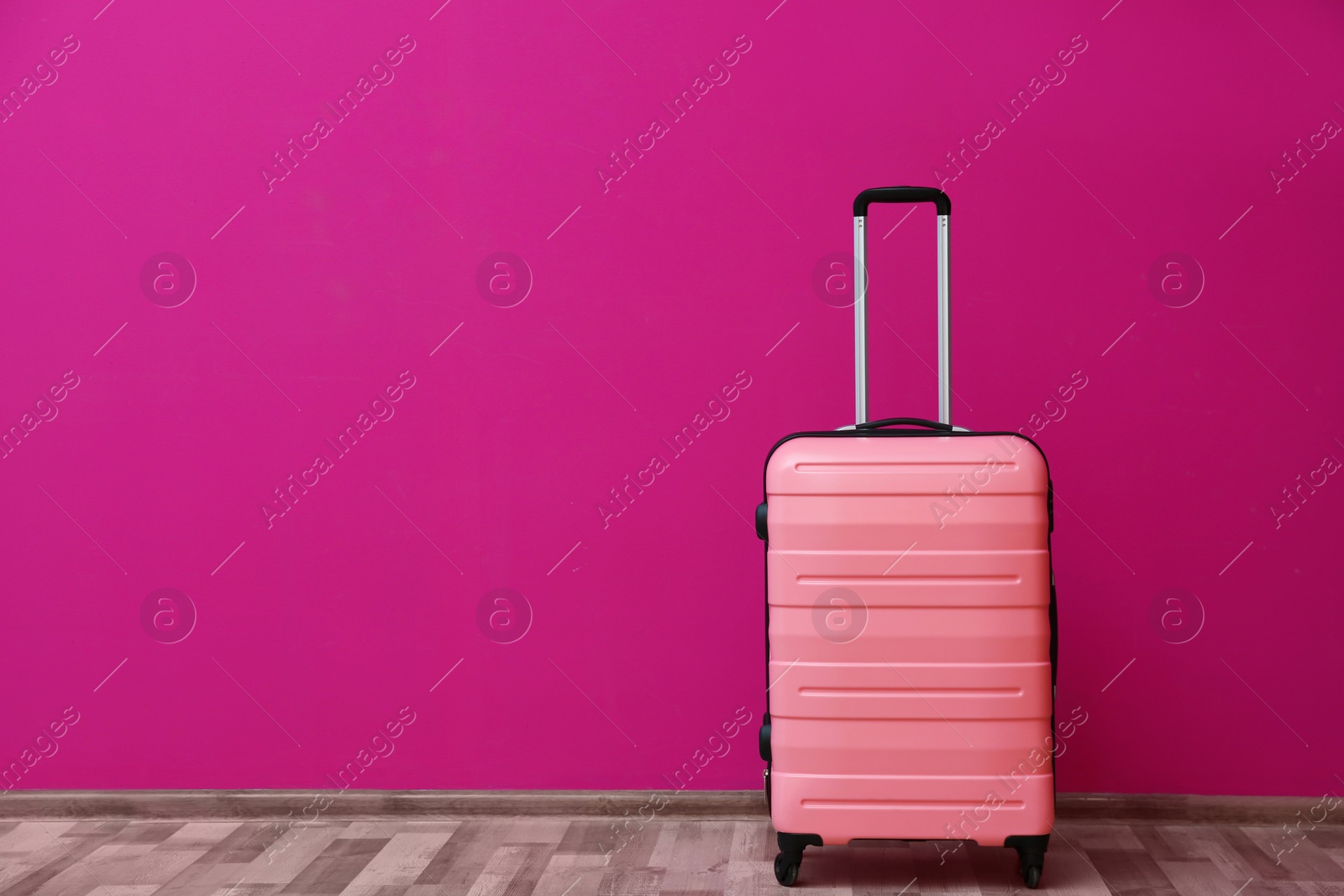 Photo of Packed suitcase near color wall with space for text
