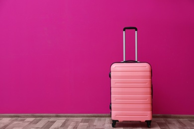 Packed suitcase near color wall with space for text