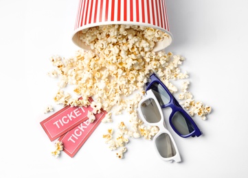 Photo of Bucket of fresh popcorn, tickets and 3D glasses on white background, top view. Cinema snack