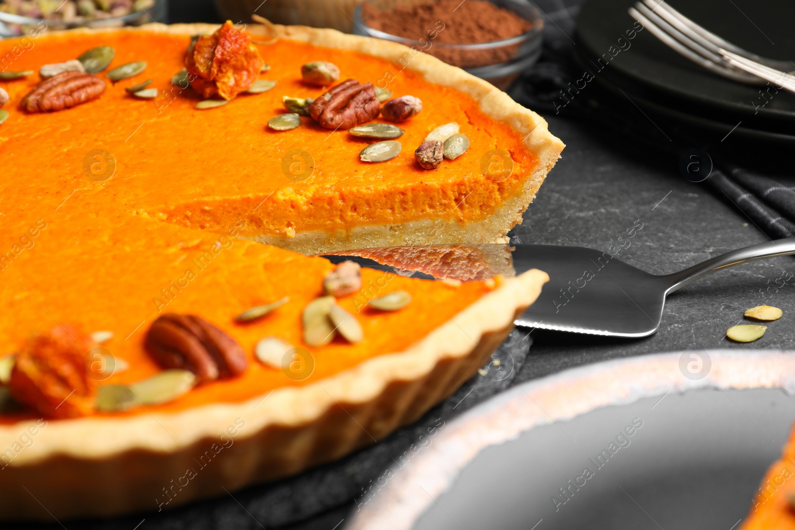 Photo of Delicious homemade pumpkin pie on black table, closeup