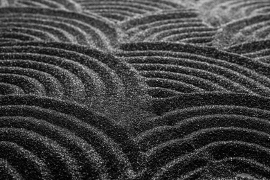 Black sand with beautiful pattern, closeup. Zen concept