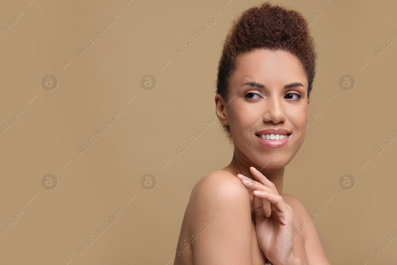 Photo of Portrait of beautiful young woman with glamorous makeup on light brown background. Space for text