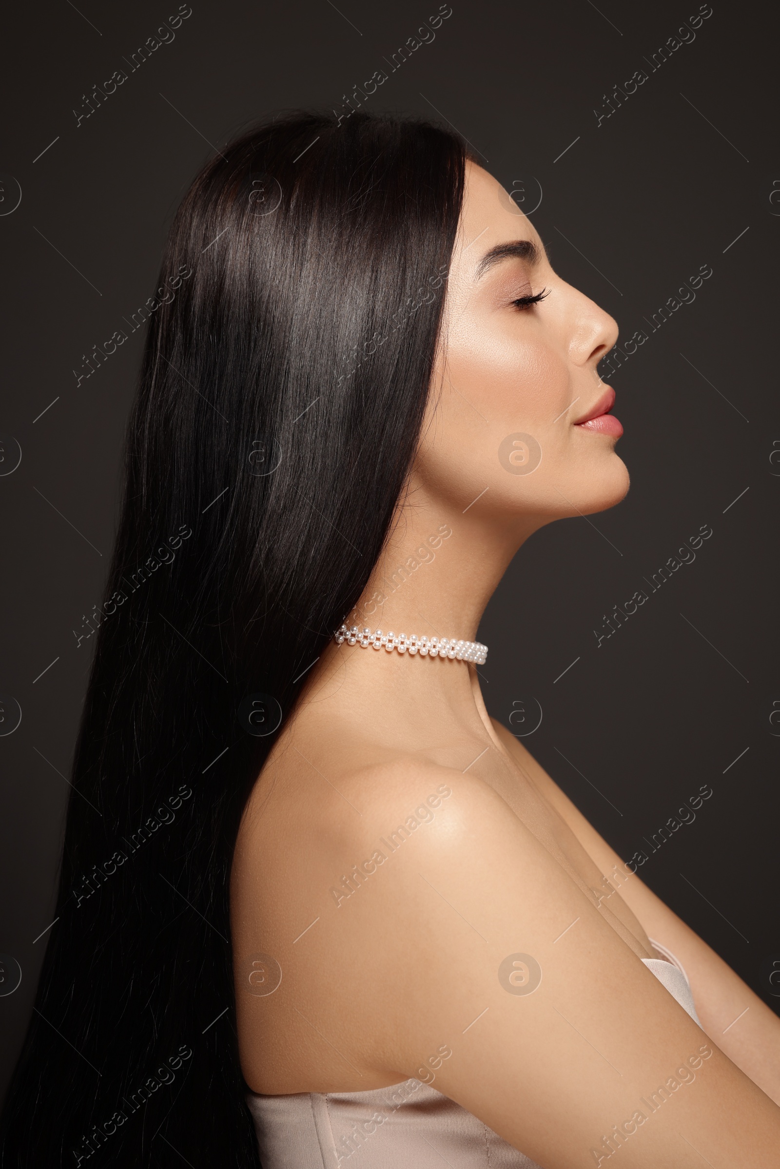Photo of Young woman with beautiful makeup on black background