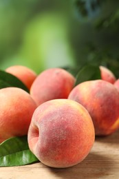 Photo of Many whole fresh ripe peaches on wooden table against blurred background, closeup. Space for text