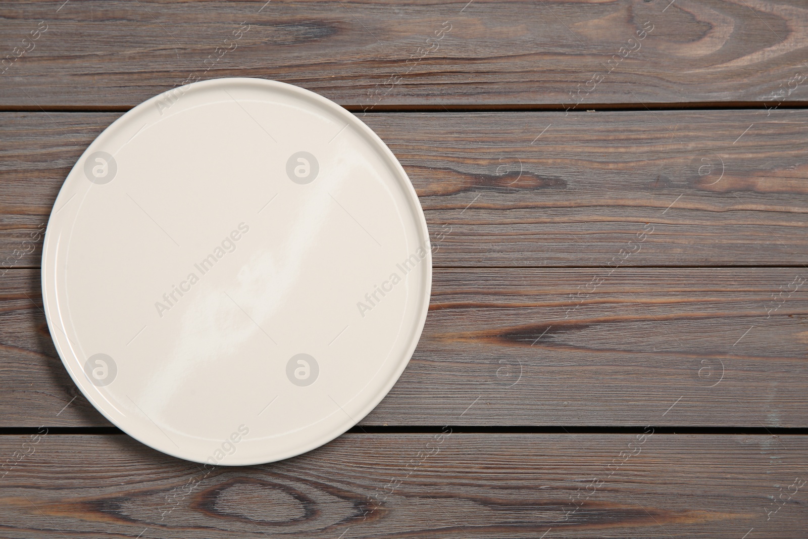 Photo of One ceramic plate on grey wooden table, top view. Space for text