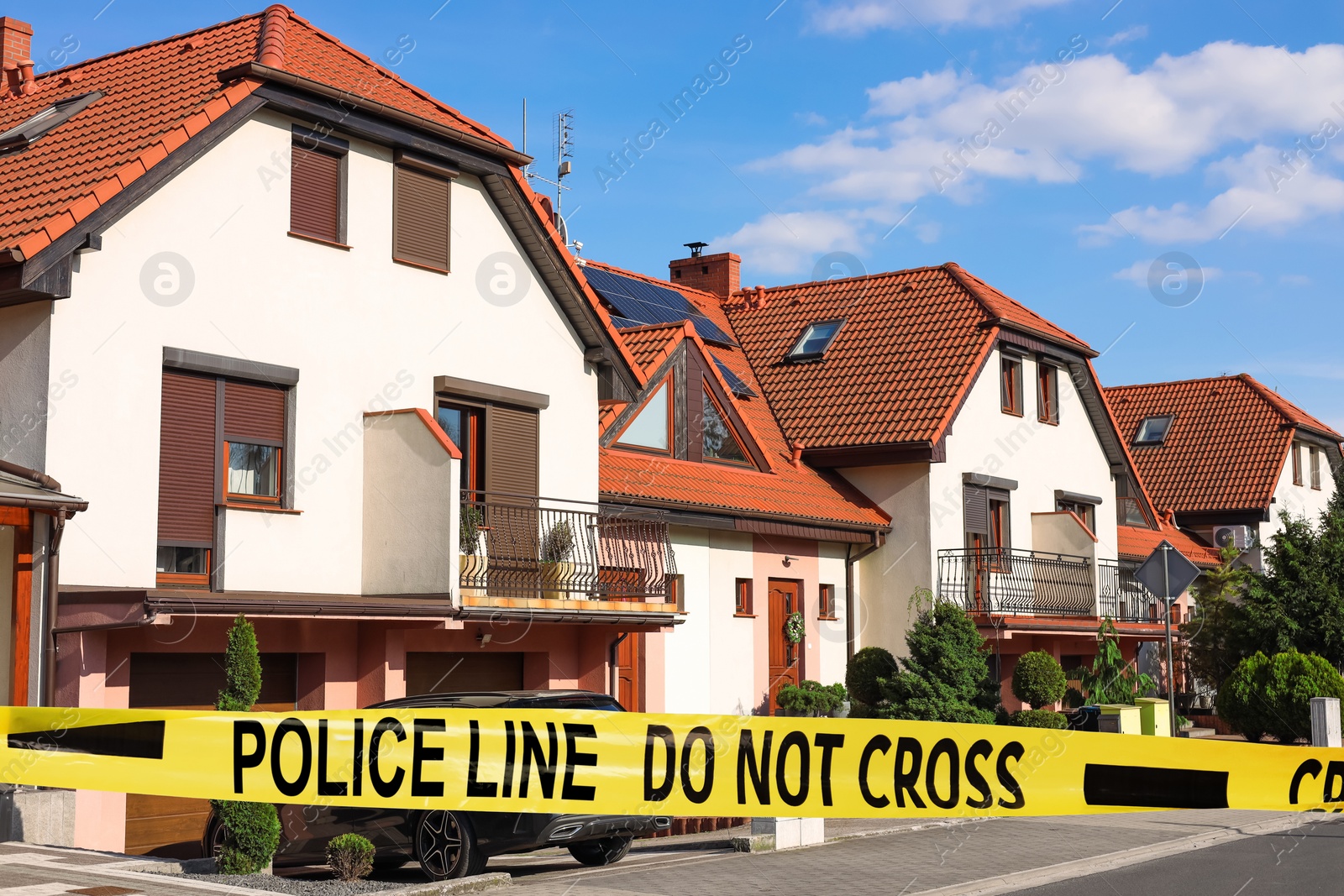 Image of Yellow crime scene tape blocking way on street