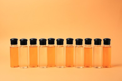 Bottles of cosmetic products on orange background