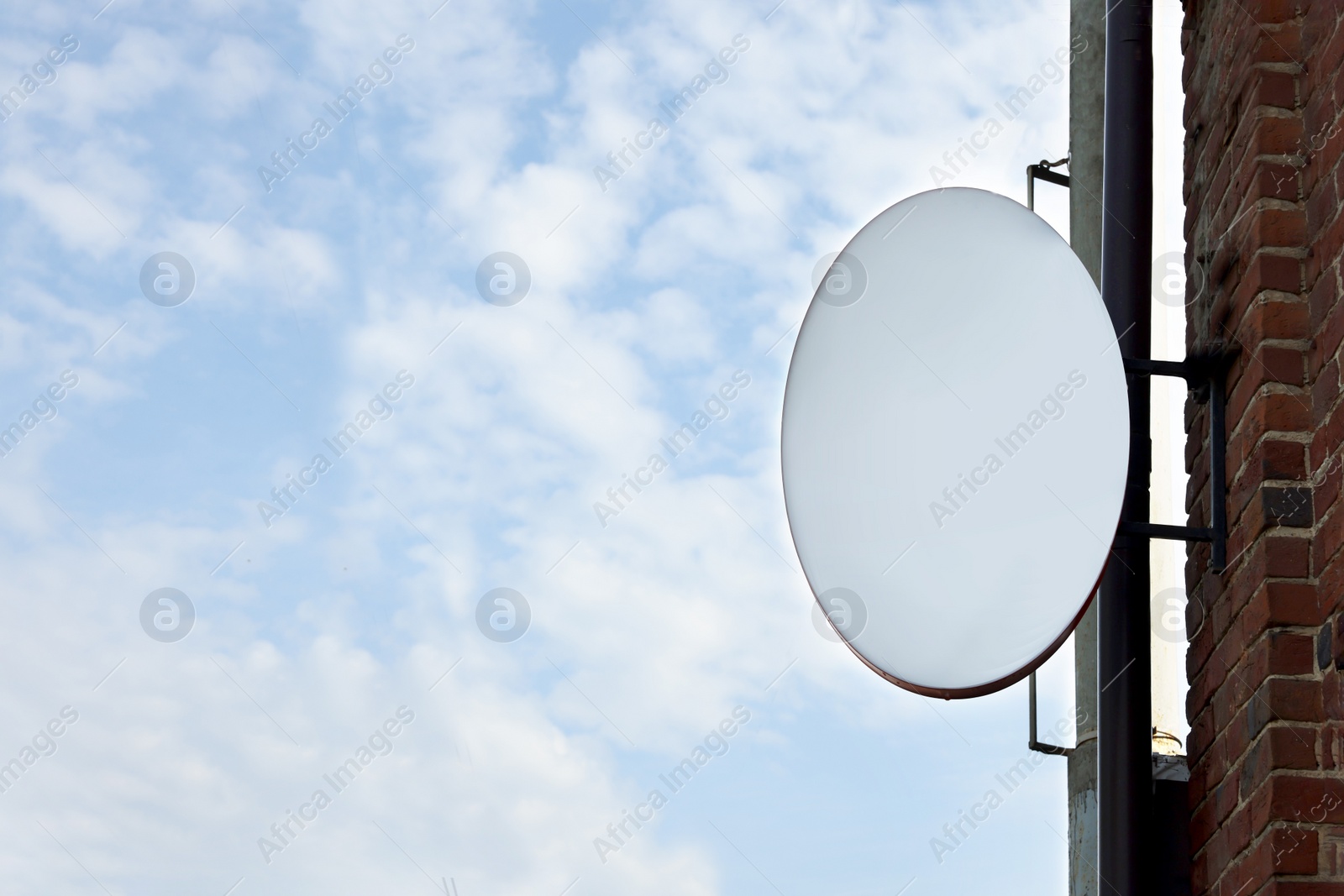 Photo of Advertising board on building wall against blue sky, space for text