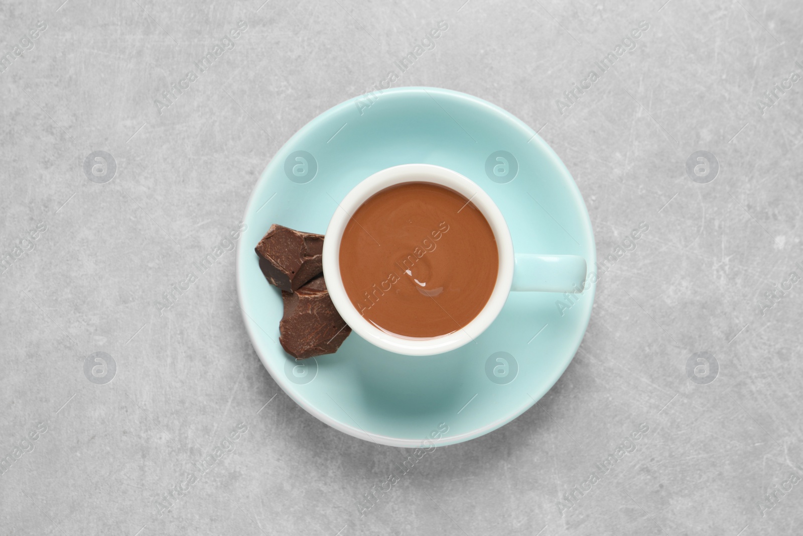 Photo of Yummy hot chocolate in cup on light grey table, top view