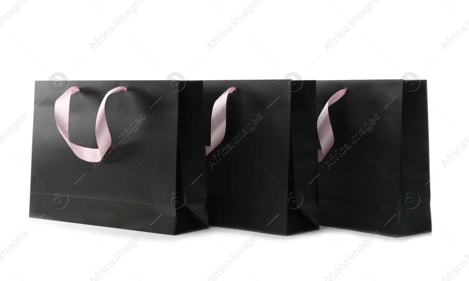 Photo of Paper shopping bags with ribbon handles on white background. Mockup for design