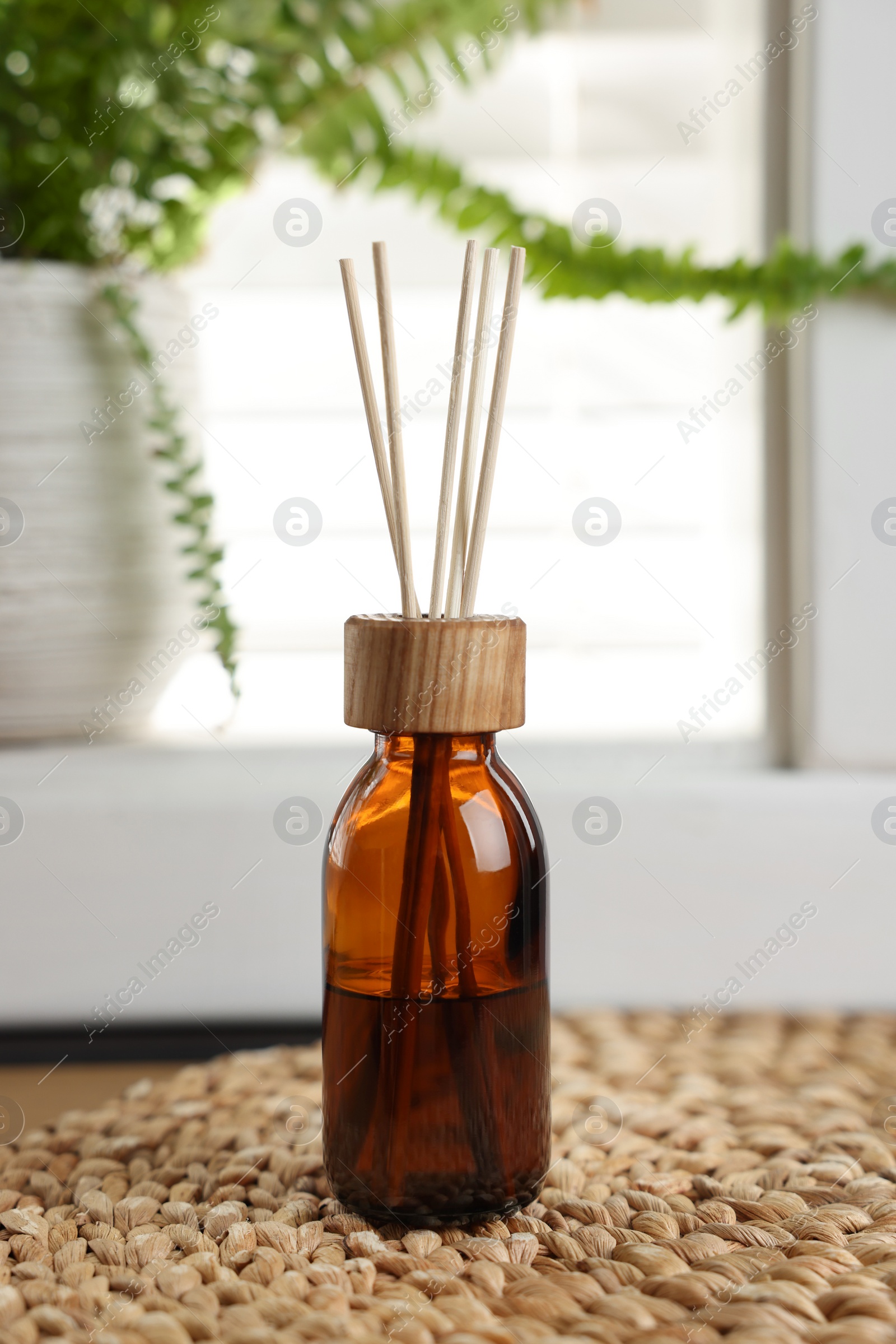 Photo of Air reed freshener and wicker mat on table indoors