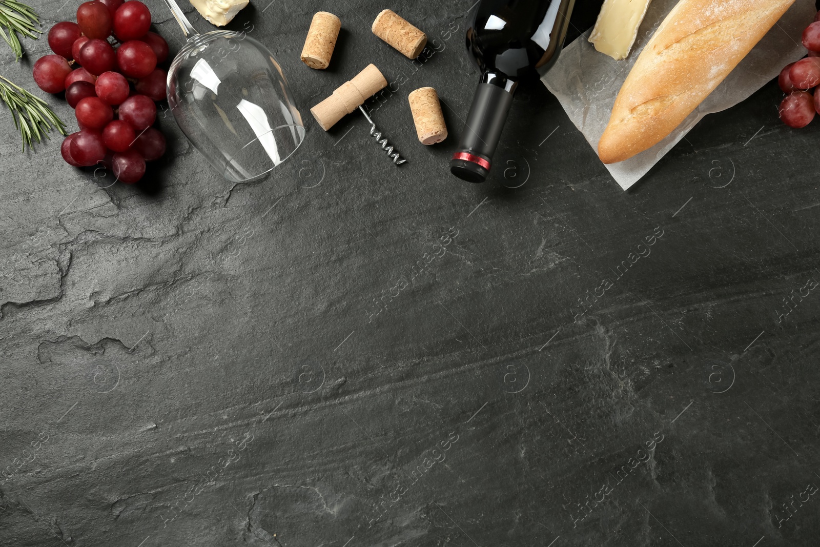 Photo of Flat lay composition with red wine and snacks on black table, space for text