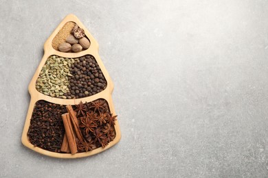 Photo of Different spices and nuts on gray textured table, top view. Space for text