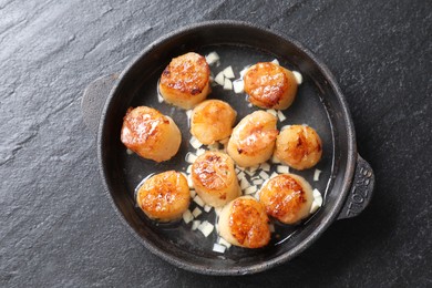 Photo of Delicious fried scallops on dark gray textured table, top view