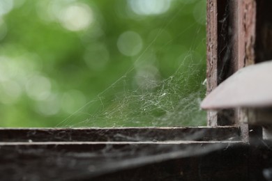 Photo of Cobweb on old wooden window frame indoors, closeup