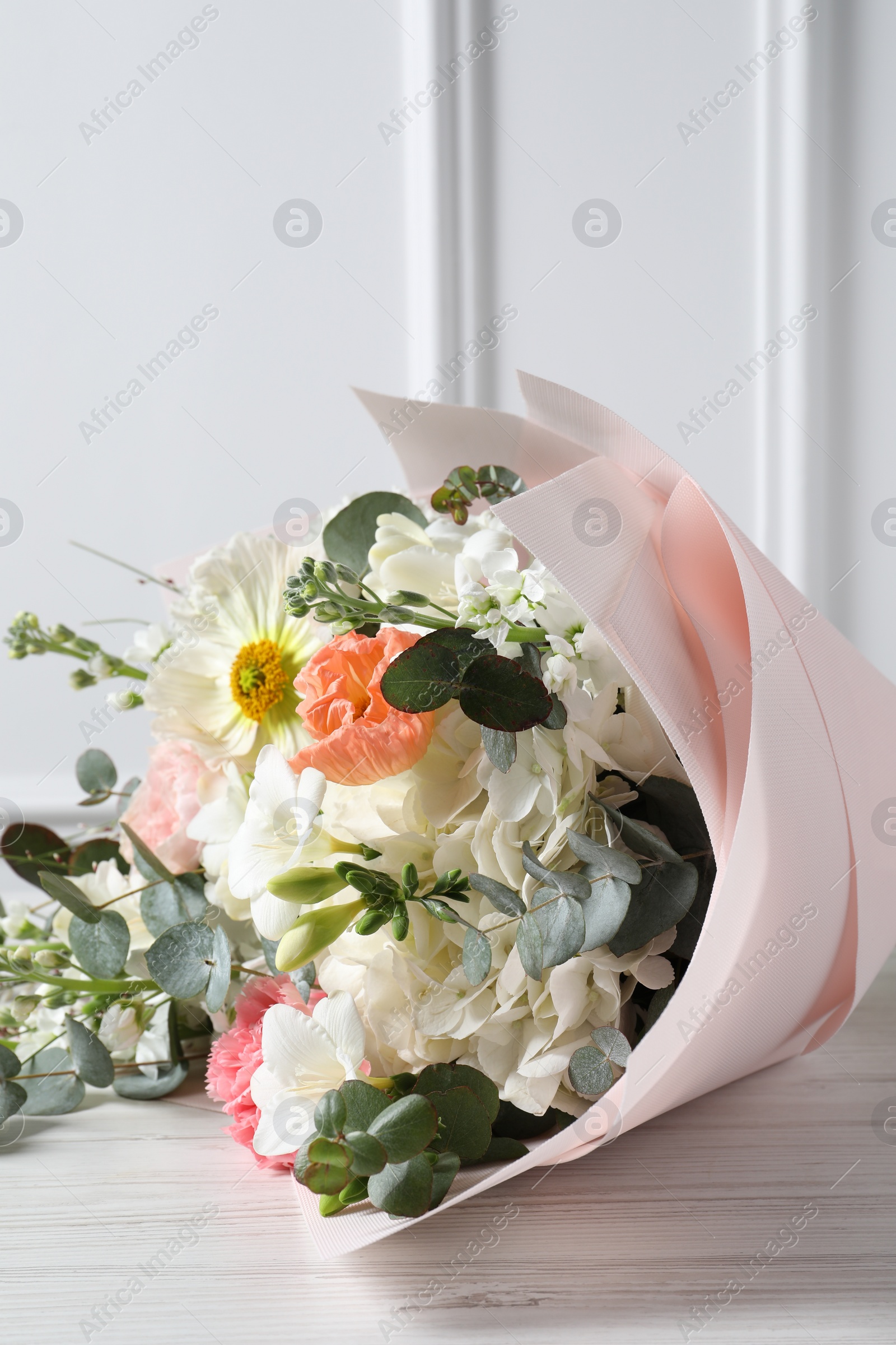 Photo of Bouquet of beautiful flowers on white wooden table, closeup